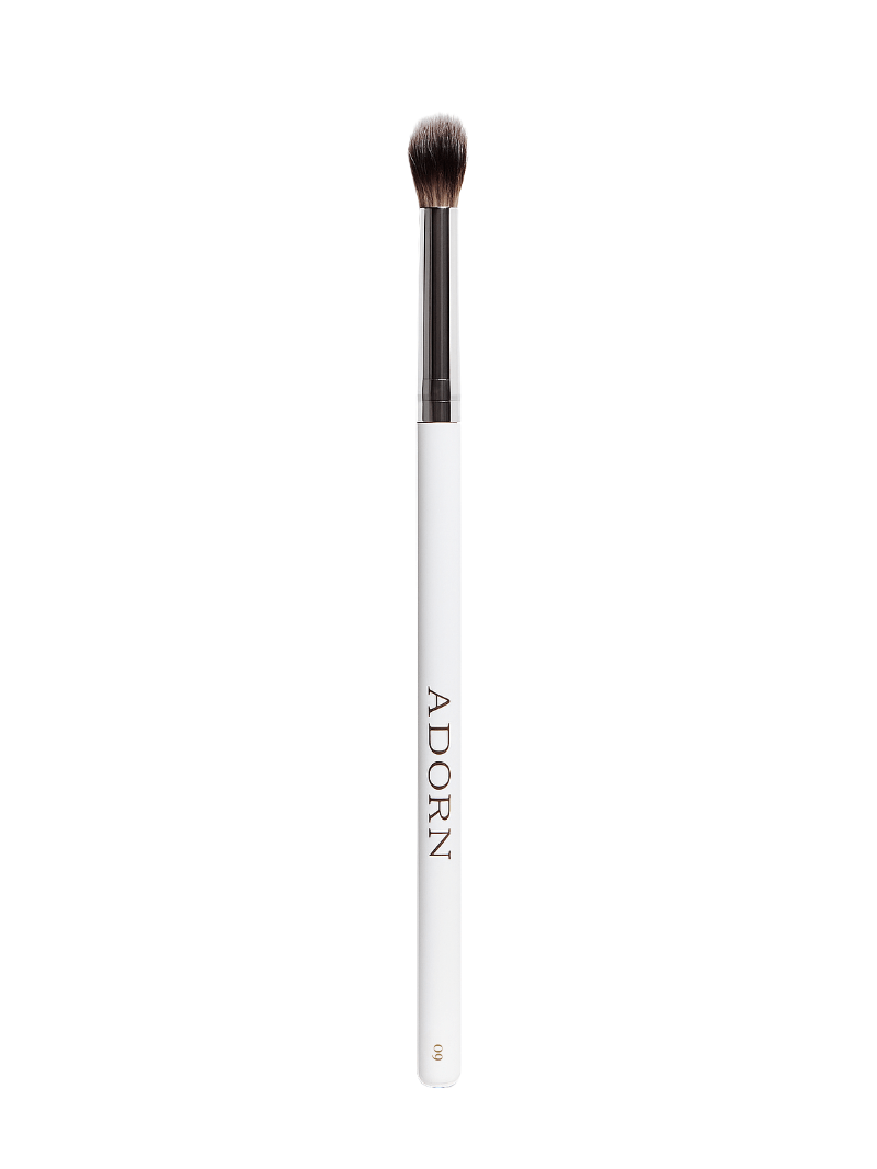 Vegan eyeshadow makeup brush with white handle and black bristles on a white background, branded 'Adorn'.