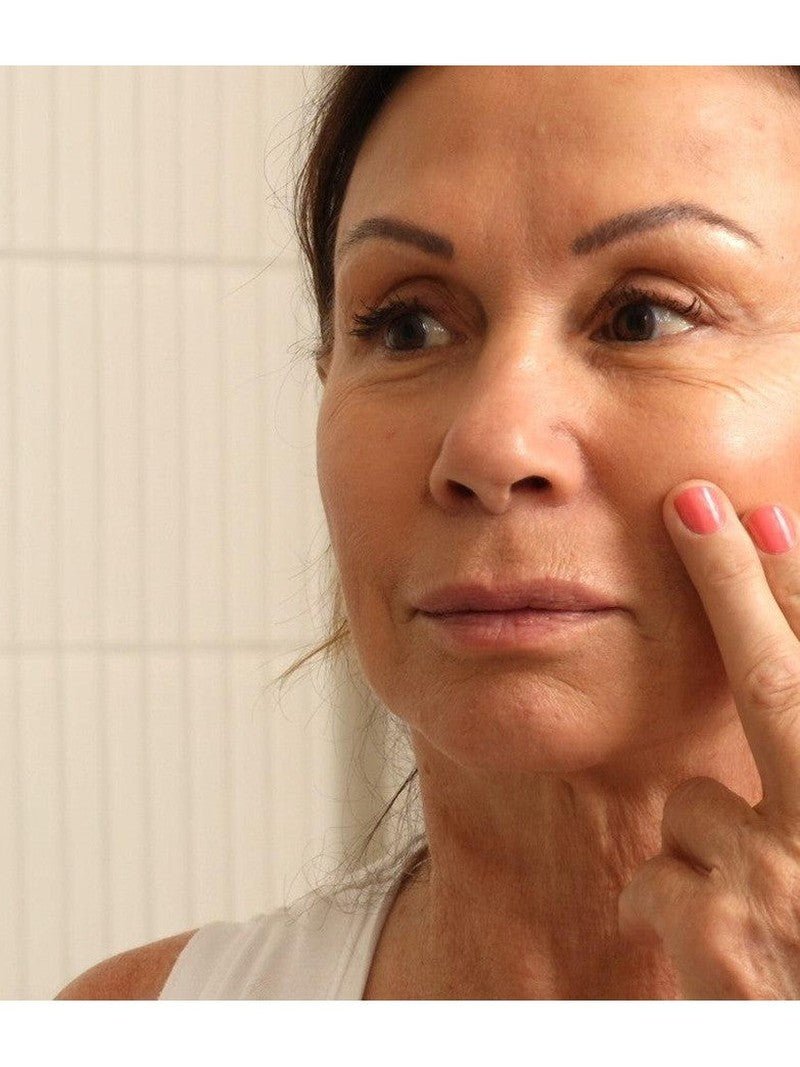 Collagen repair cream for mature skin on mature woman's face.