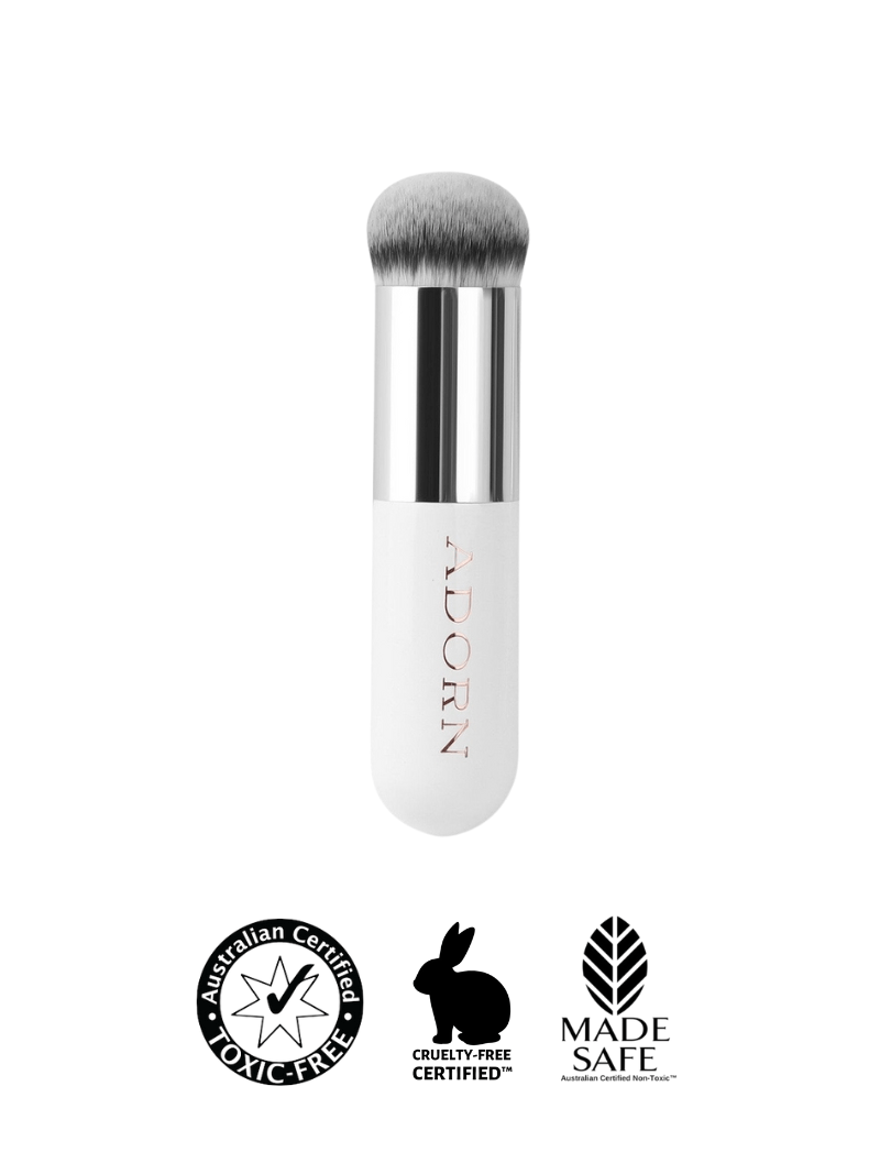 Cream makeup brush with brand logo and certification icons on a white background