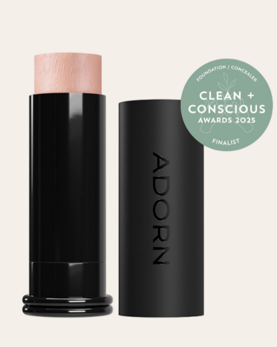 Adorn Cream foundation stick featuring a 'Clean + Conscious Awards 2025' badge.