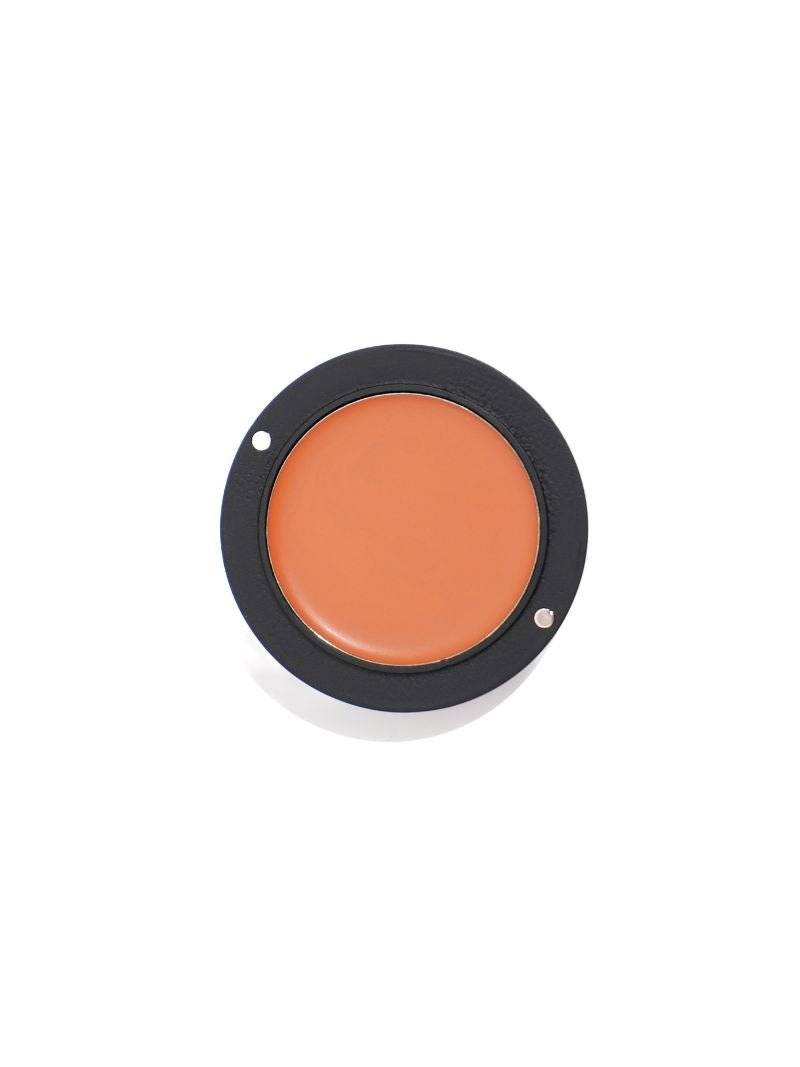 Cosmetic cream in a round container with a black lid on a white background
