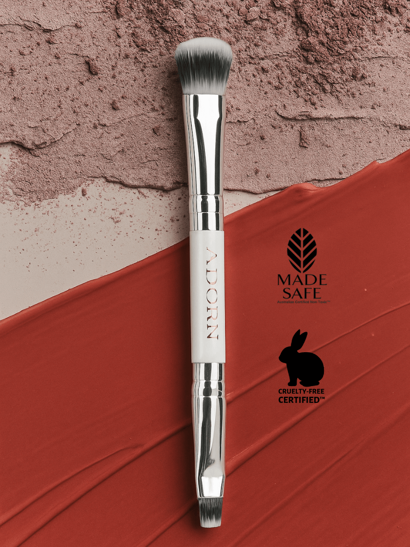Makeup brush with 'Made Safe' and 'Cruelty Free Certified' logos on a textured background