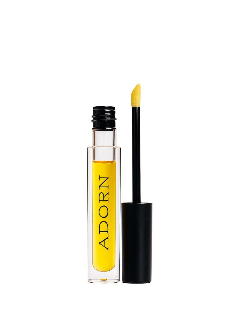 Natural lip oil Australia with black applicator and 'ADORN' branding on a white background.