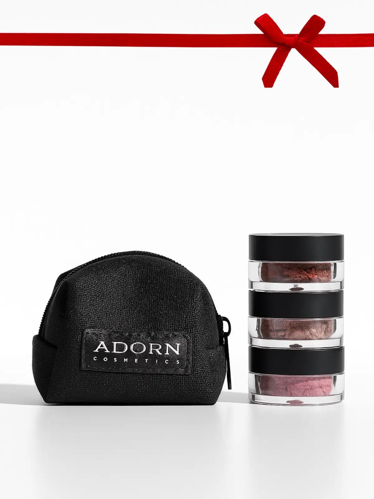 Black cosmetic bag with 'Adorn Cosmetics' logo and a stack of makeup containers on a white background.