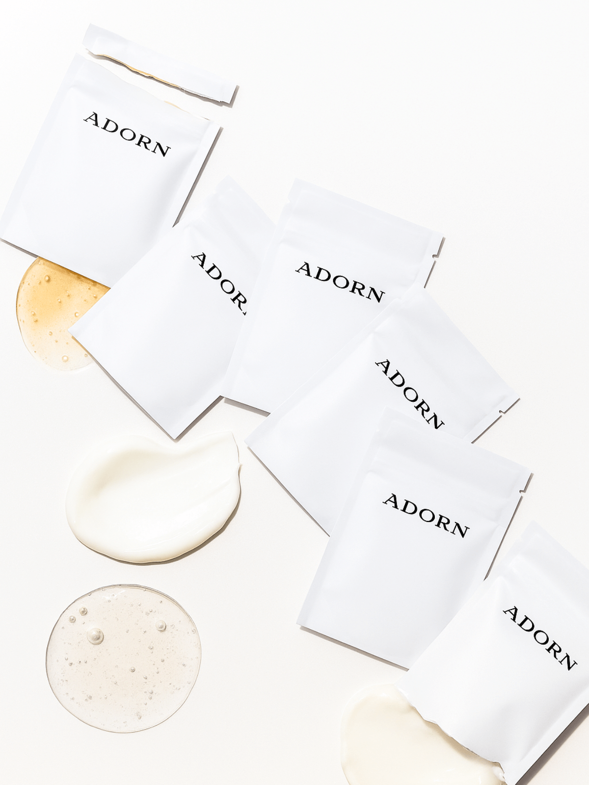 White skincare samples for mature skin packaging with 'ADORN' branding on a light background