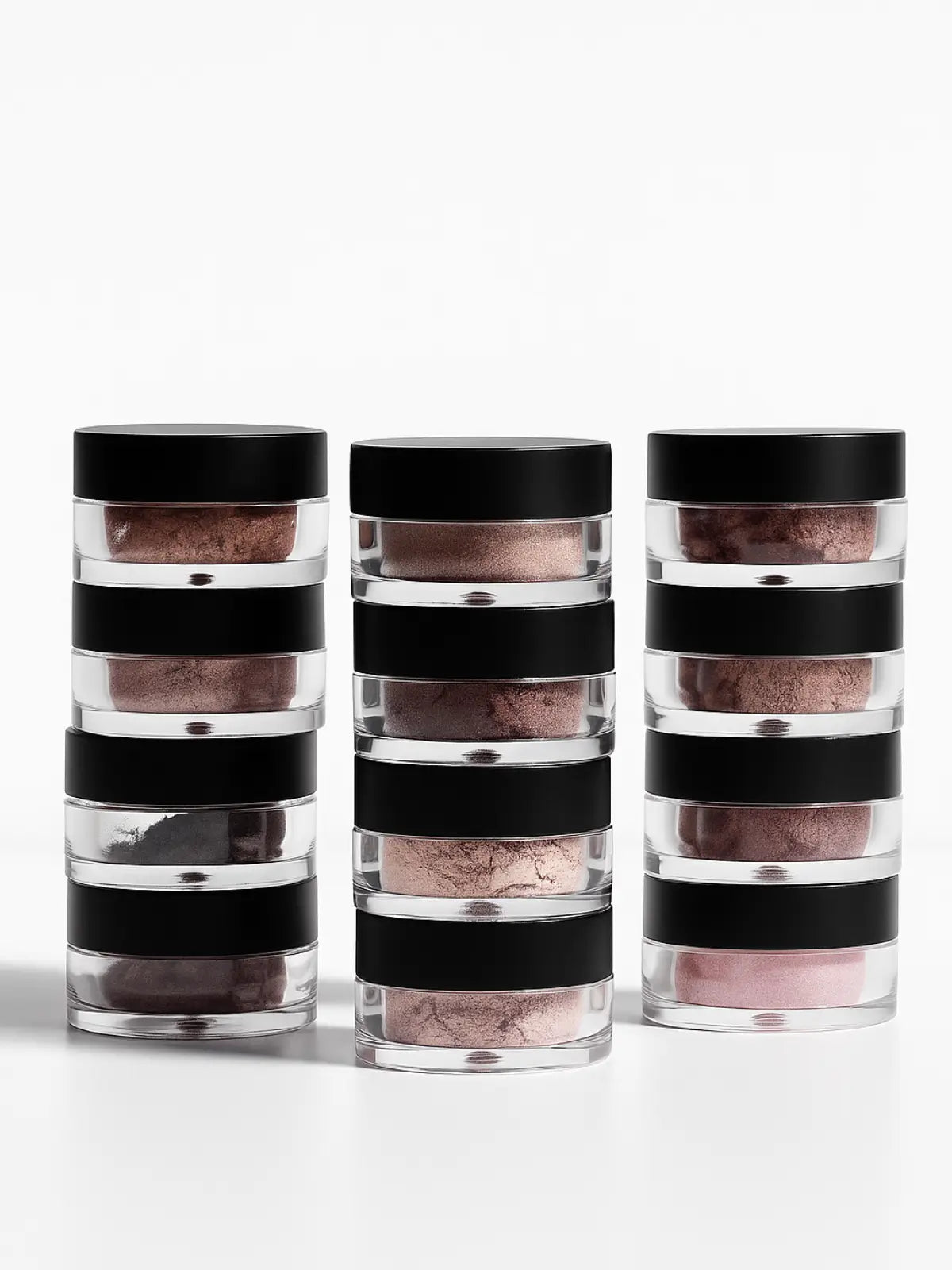 Three cylindrical containers with black lids stacked on a white background, with a red ribbon at the top.