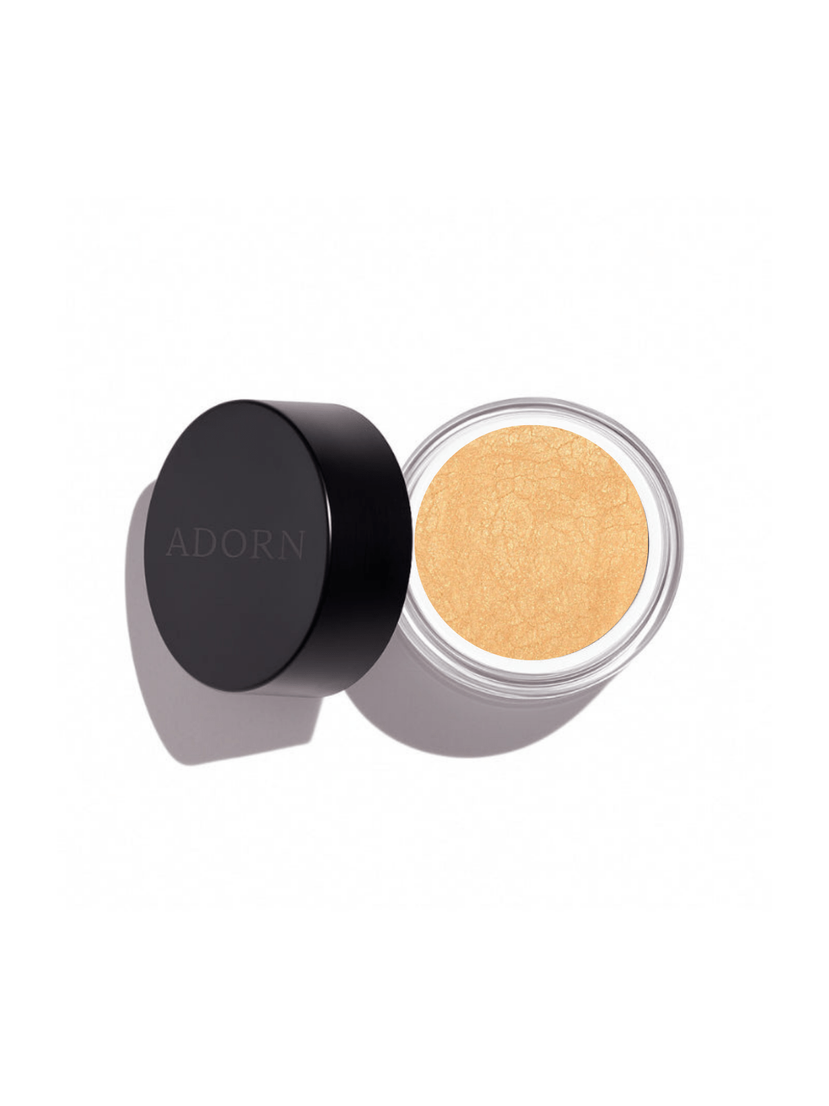 Open container of golden loose mineral eyeshadow shade coral pearl with 'ADORN' branding on a white background