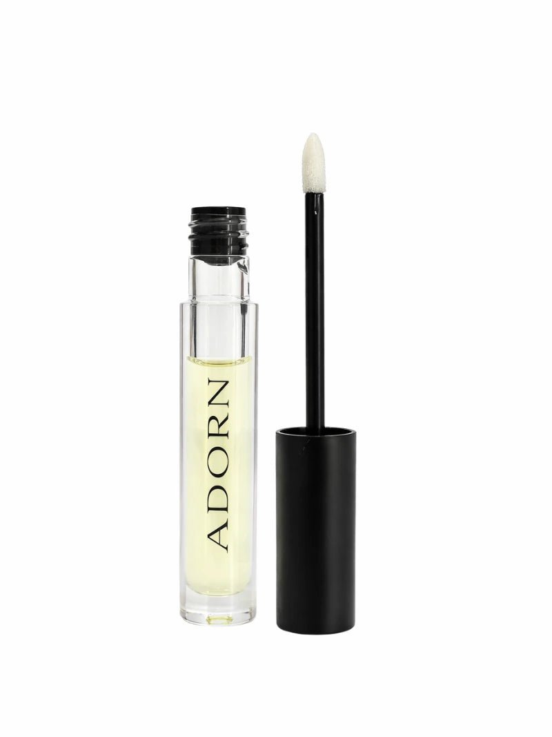 best natural lip oil australia with black applicator and clear container labeled 'ADORN' on a white background