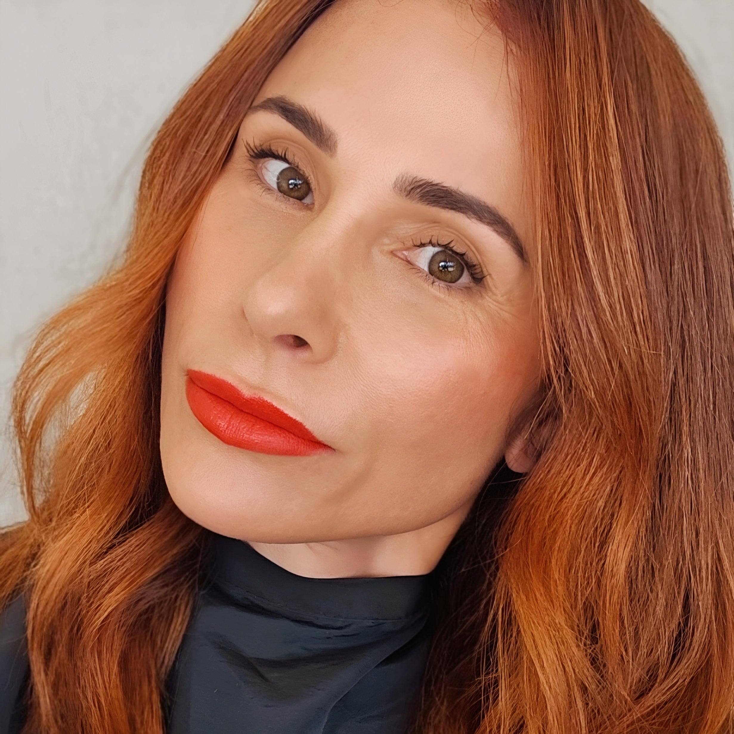 Mature Woman with red hair and bright red lipstick adorn cosmetics