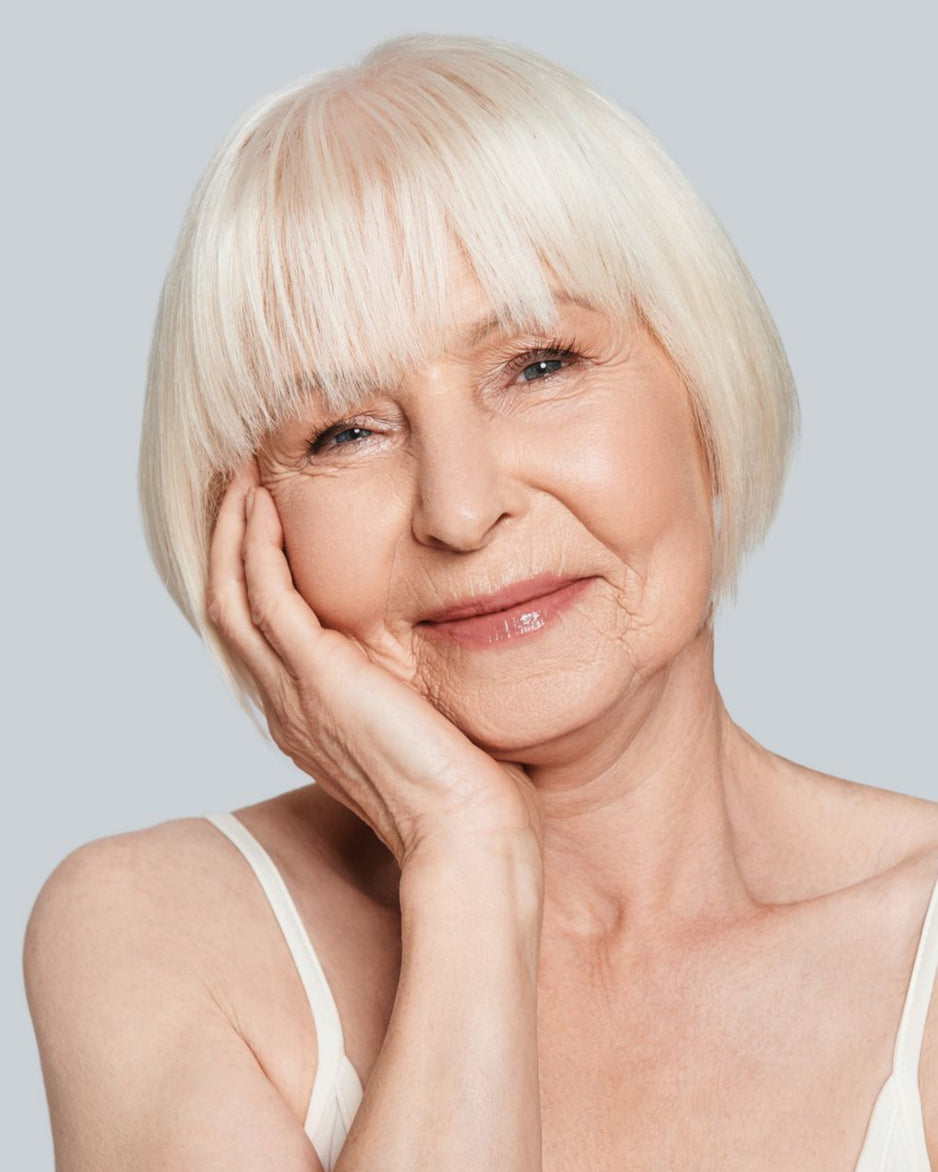 Mature Woman wearing cream foundation and glow cream.