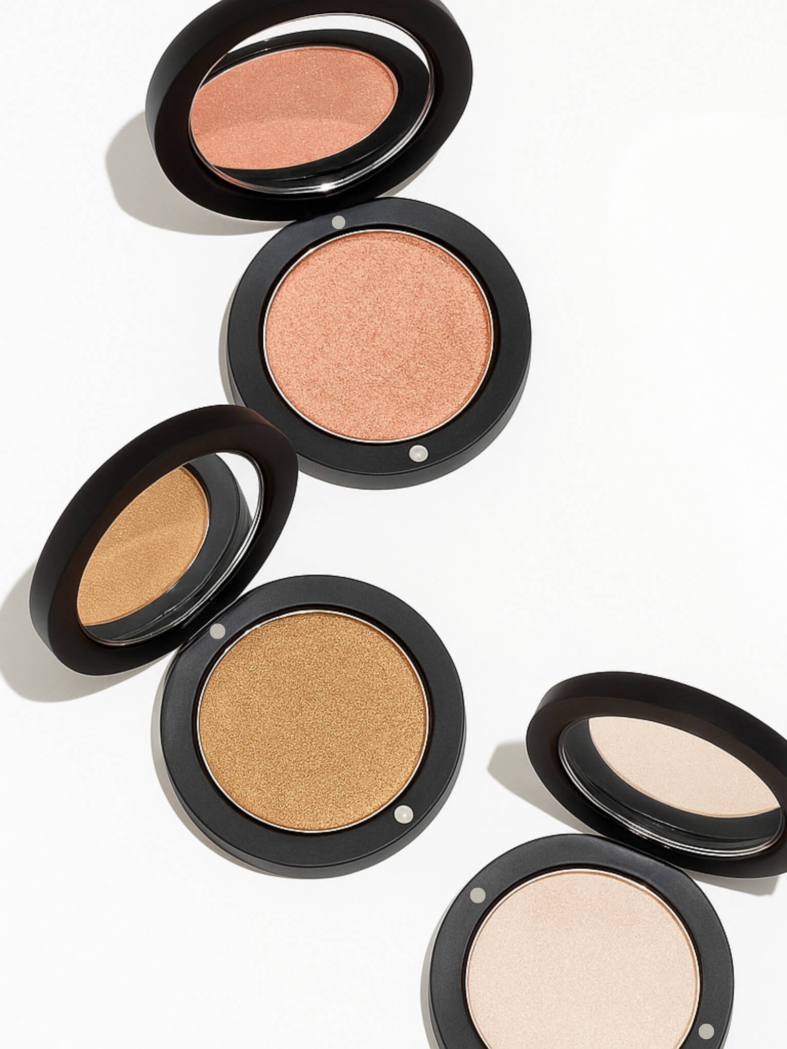Set of makeup compacts with different shades on a white background