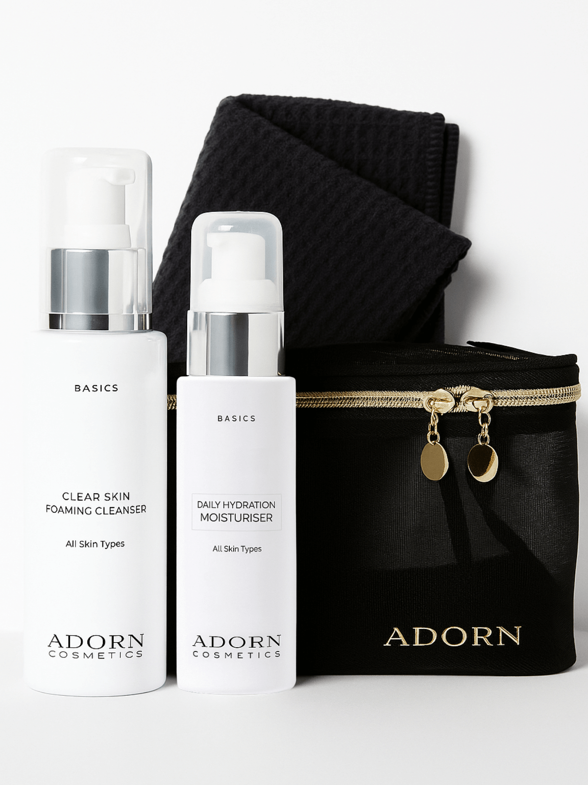 Two skincare bottles labeled 'Basics' by Adorn Cosmetics with a black pouch on a white background.