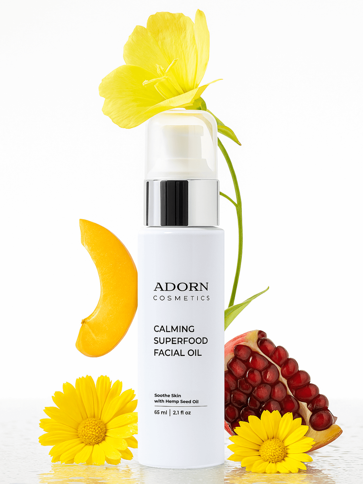 Adorn Cosmetics Calming Superfood Facial Oil with yellow flowers and pomegranate on a white background