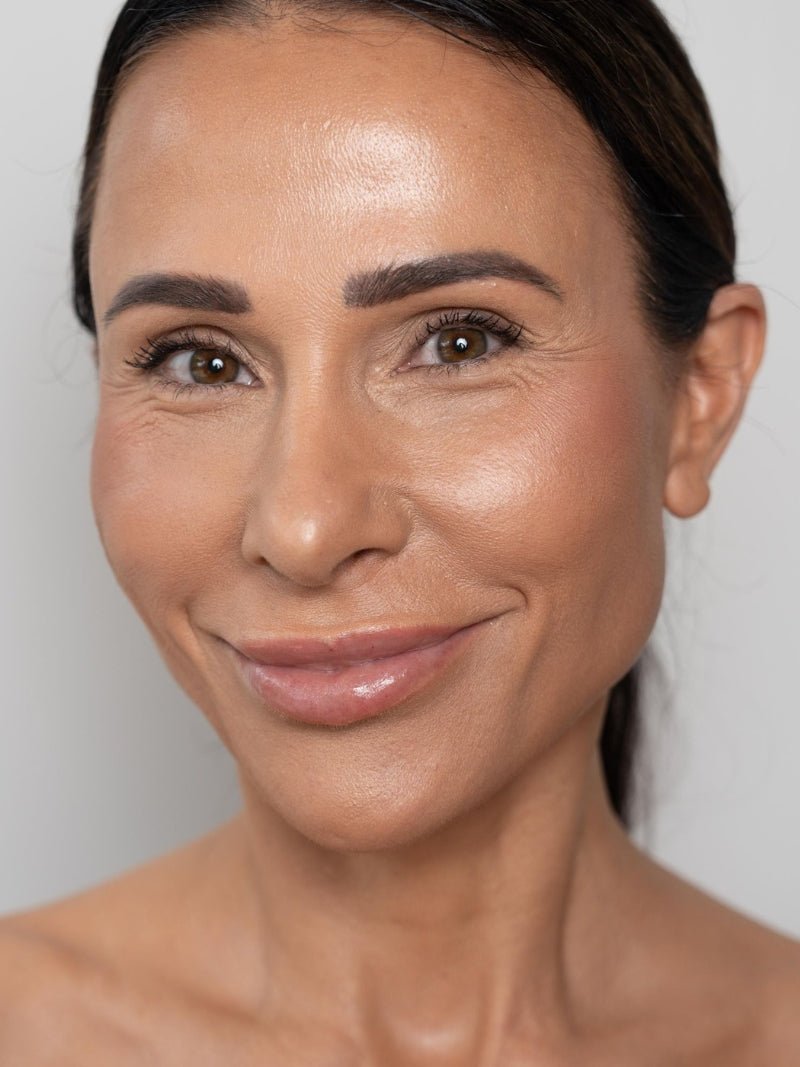 Adorn's founder Briony after skin results using best skin tightening cream for face and neck Matrixyl 10% Face & Neck Wrinkle Cream silver bottle on a white background.