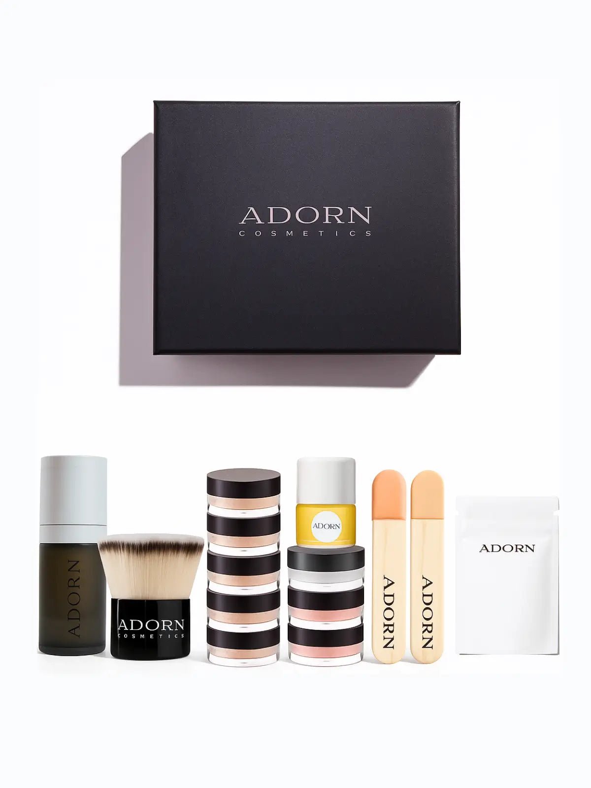 Adorn Cosmetics online foundation samples set including bottles, jars, and a box on a white background