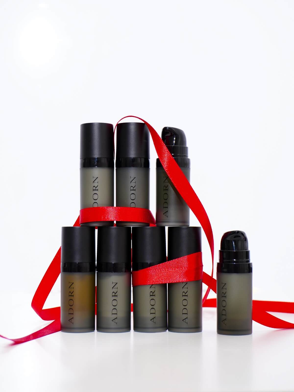 Set of Adorn skincare products with red ribbon on a white background