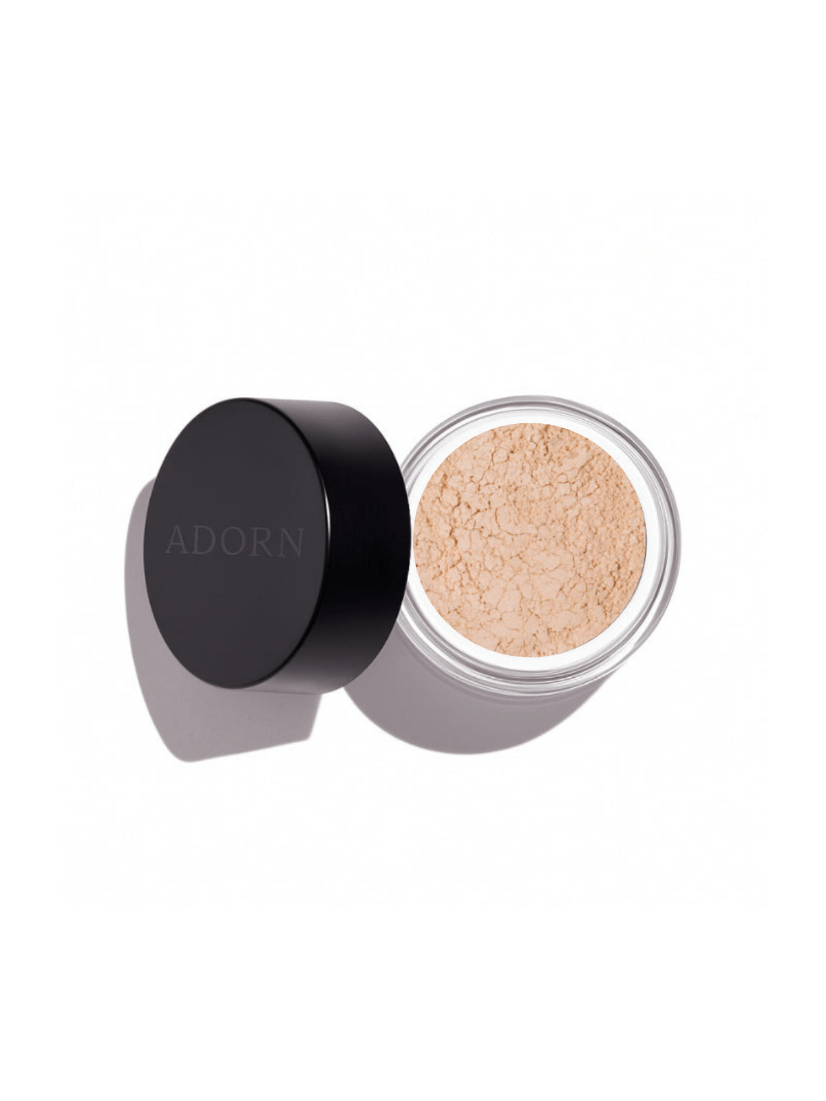 Open container of loose mineral eyeshadow in nude shade with 'ADORN' branding on a white background