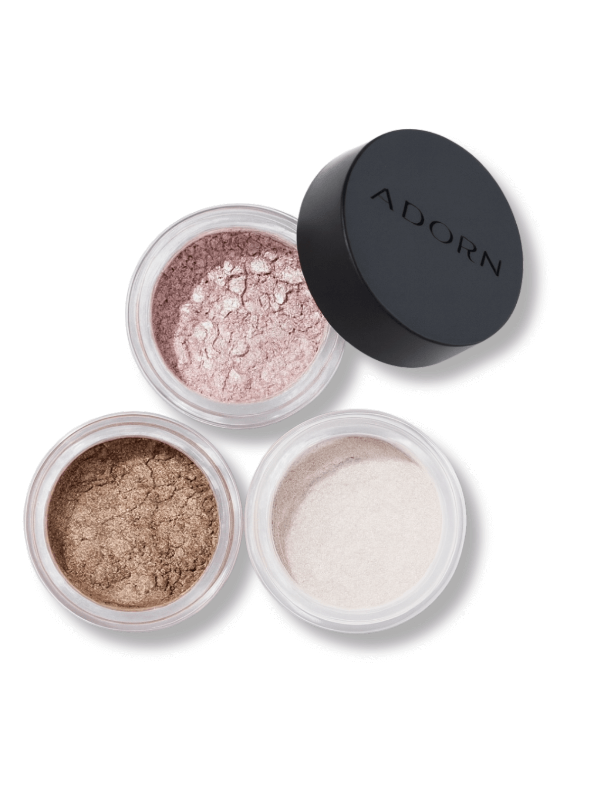Three open containers of loose mineral eyeshadow with a closed lid labeled 'Adorn' on a white background.