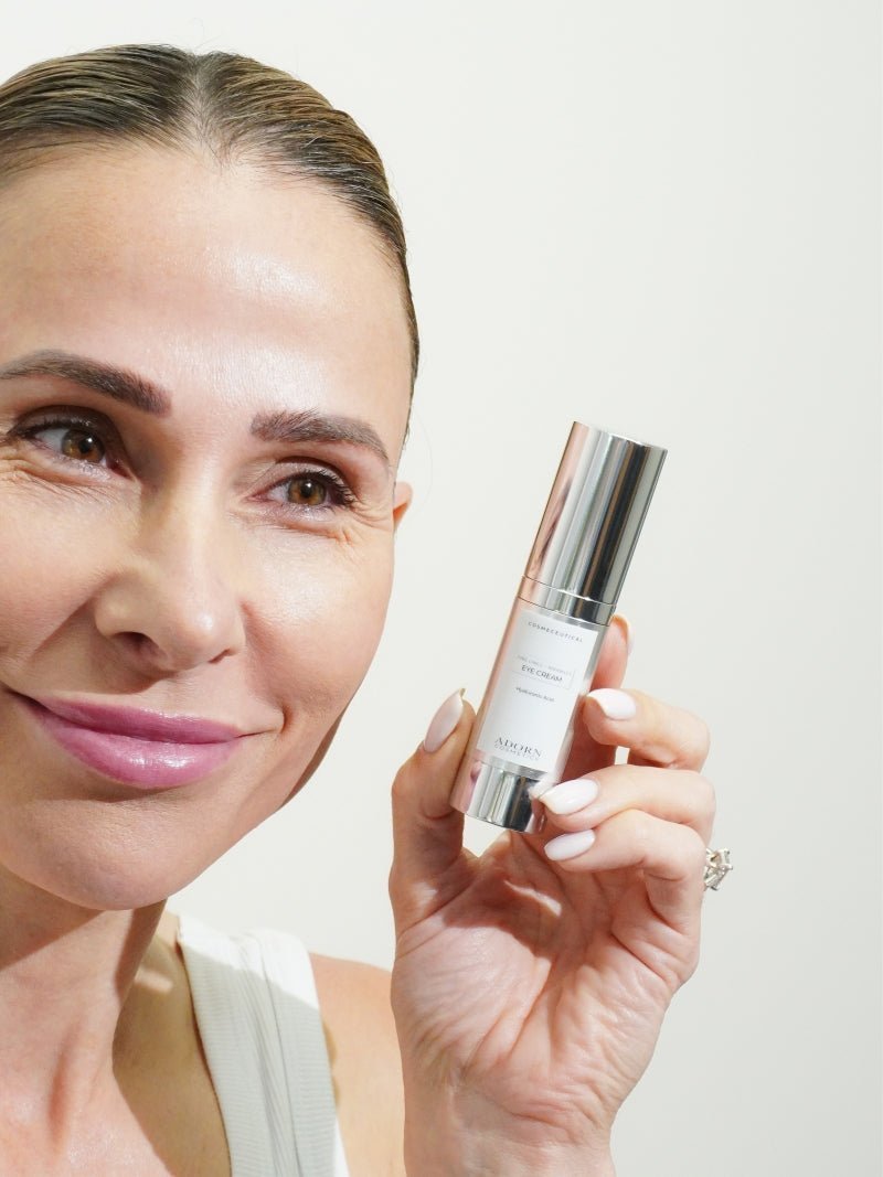 Woman holding Adorn Hyaluronic Acid Eye Cream beside her face