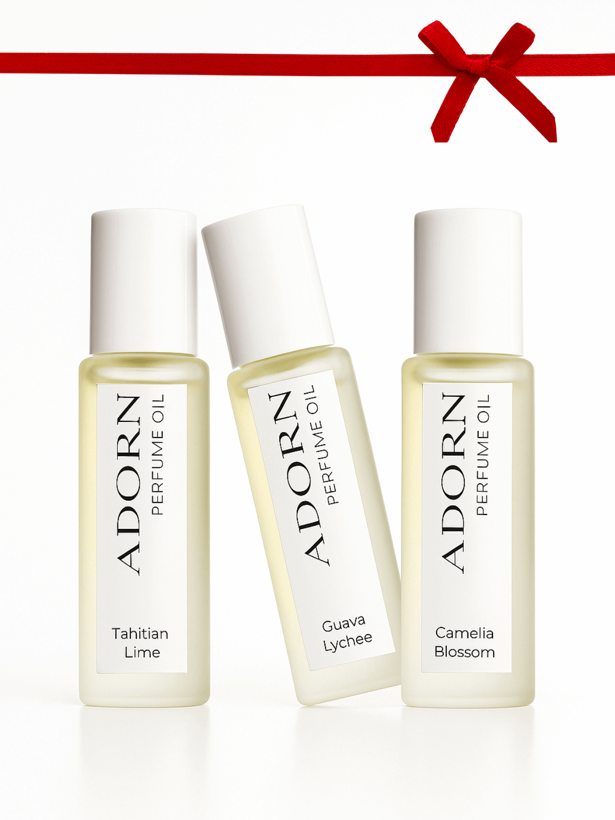 Three Adorn roll on perfume oil bottles with labels on a white background