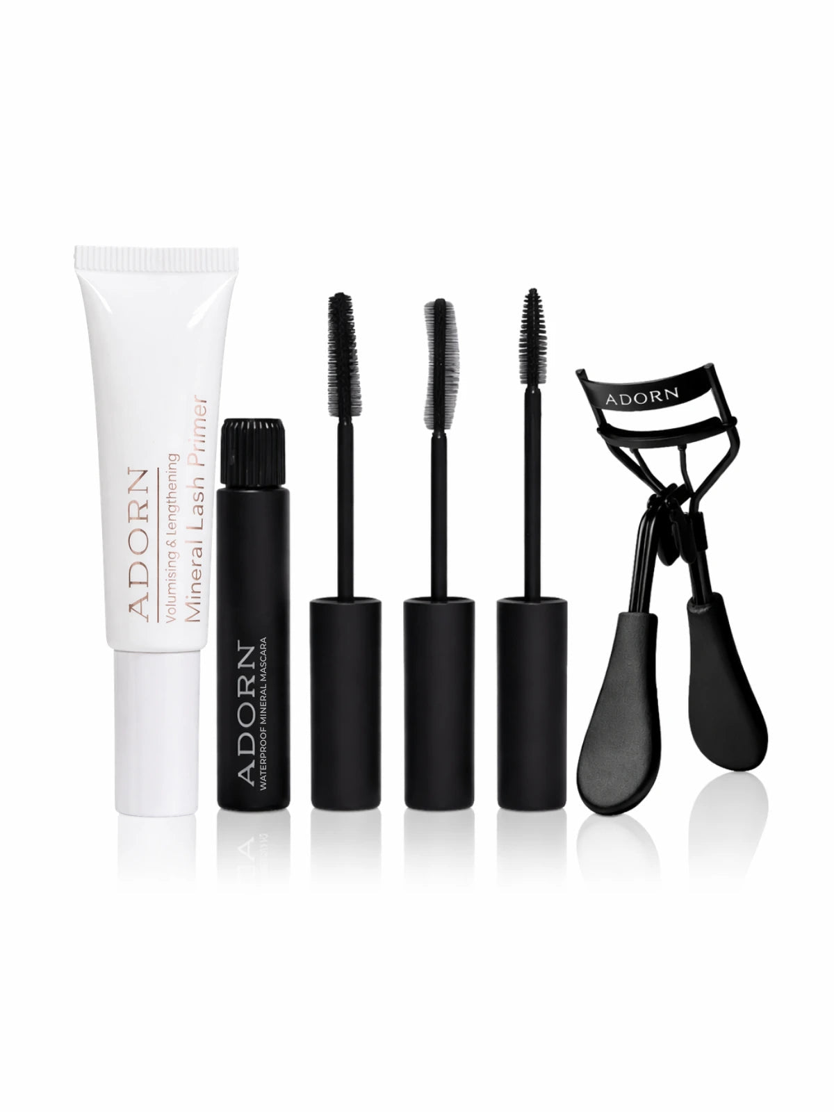 Set of Adorn eye makeup products including mascara, eyelash curler, and primer on a white background